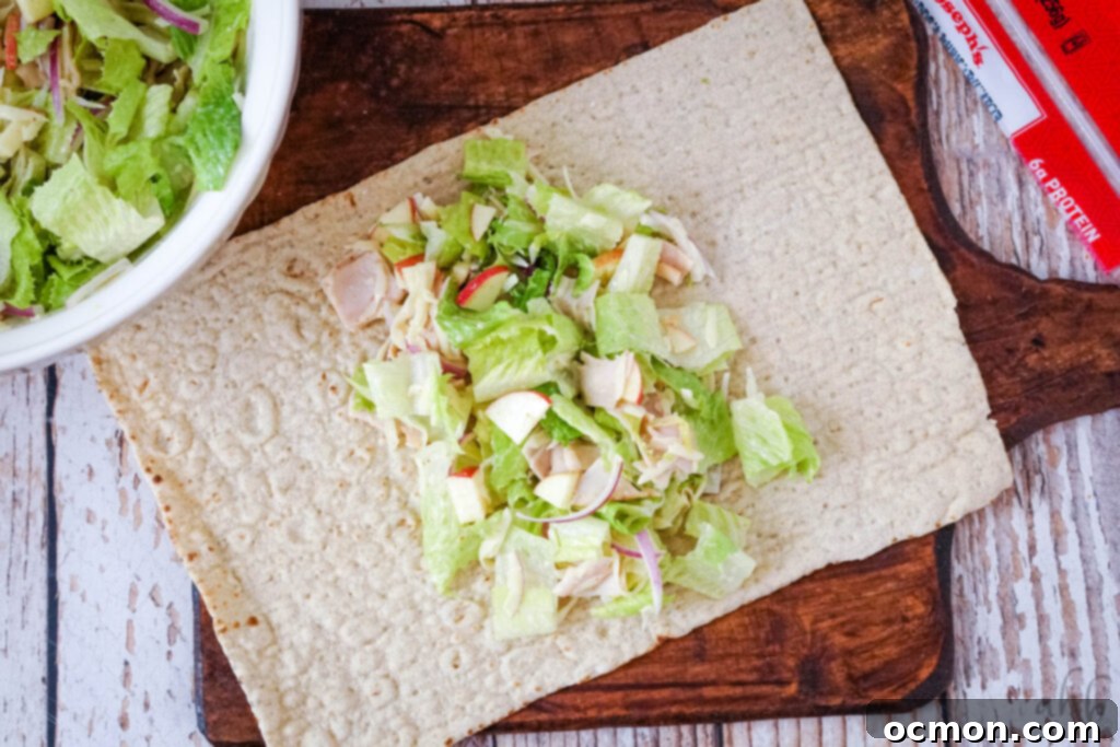 The mix is laid out in the center of a large tortilla on a wooden cutting board.