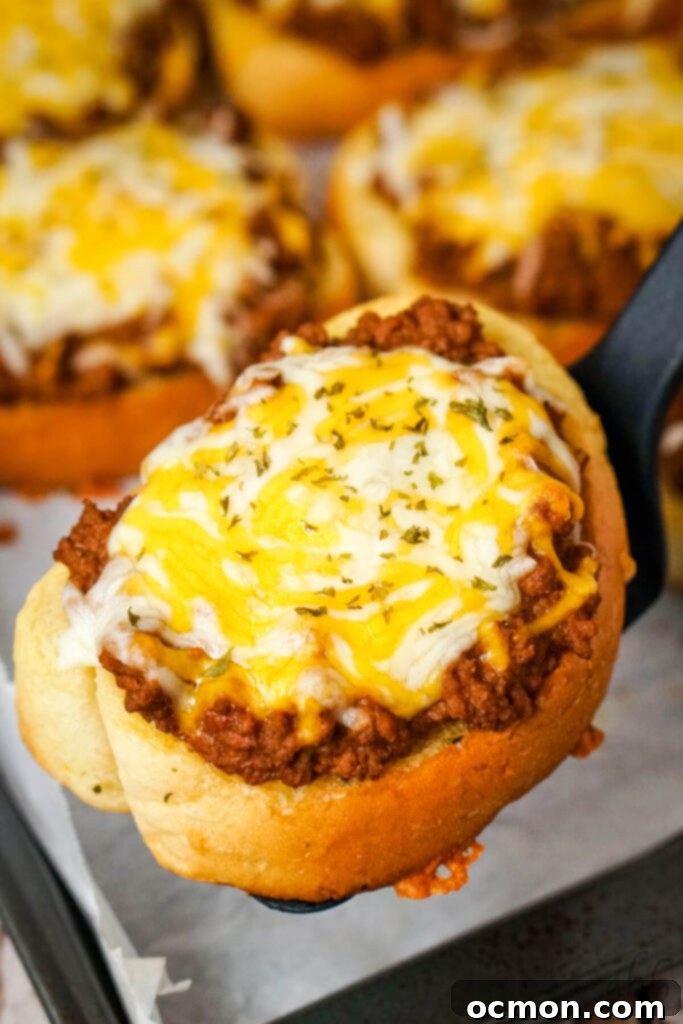 Sloppy Joe Stuffed Garlic Bread 2 Two open-faced Garlic Bread Sloppy Joes on a baking sheet, topped with melted Colby Jack cheese and fresh parsley.