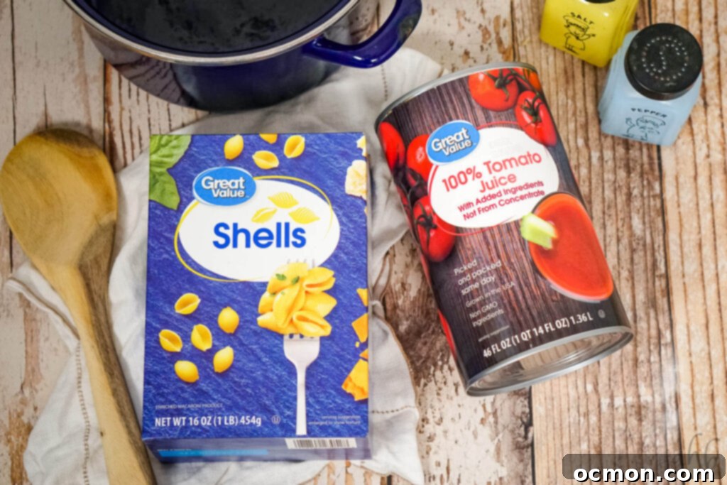 A box of shell pasta, a can of tomato juice, salt, pepper, a wooden spoon, and a blue stockpot, ready for cooking.