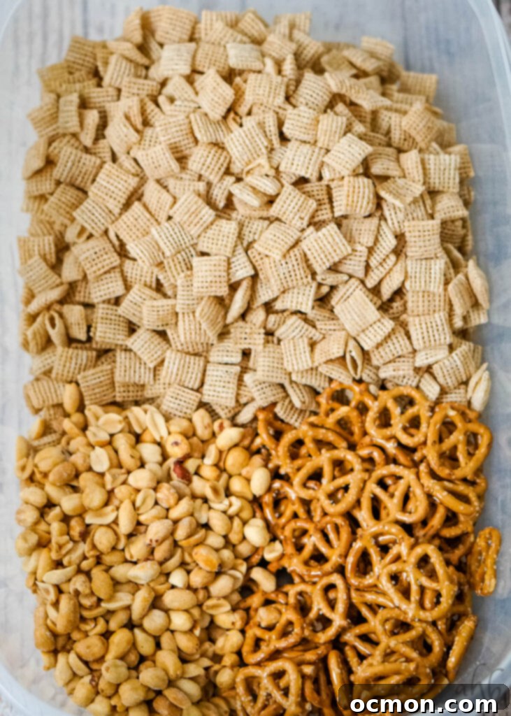 Caramel Apple Crunch Mix 5 Peanuts, pretzels, and Chex cereal are combined in a large microwaveable bowl, ready for the sweet coating.