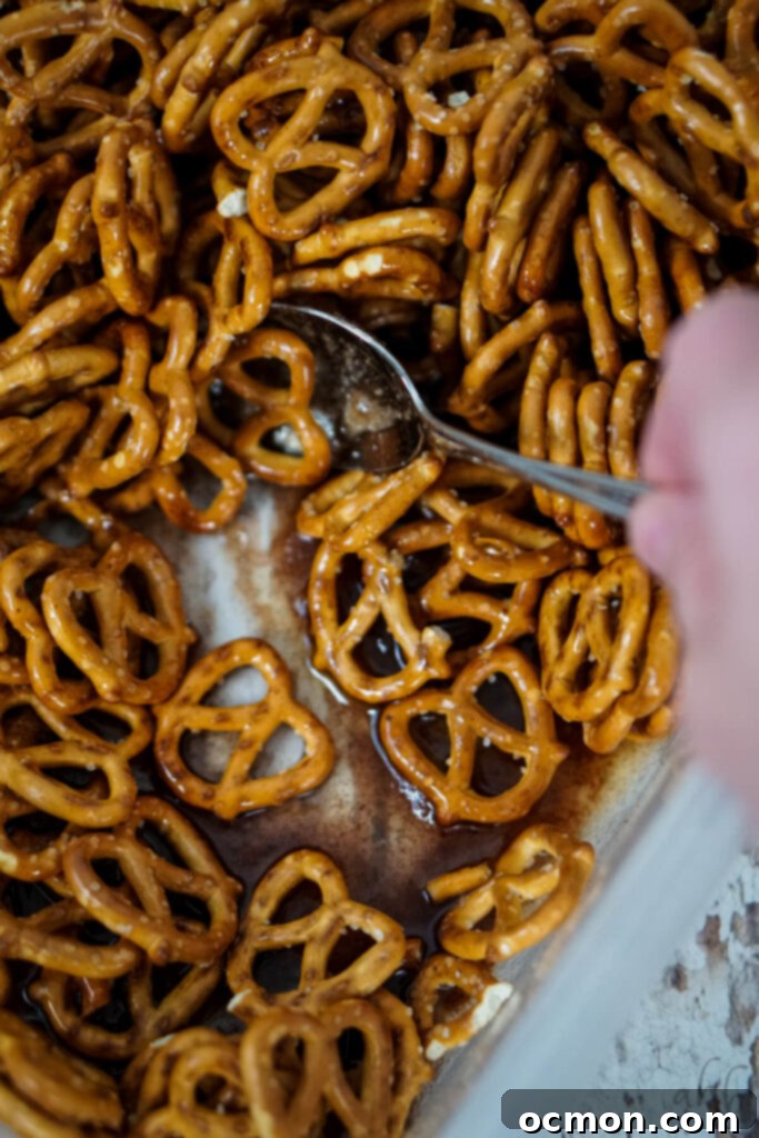 Golden Cinnamon Knots 5 Pretzels are mixed into the melted butter, sugar, corn syrup, and cinnamon with a spoon.
