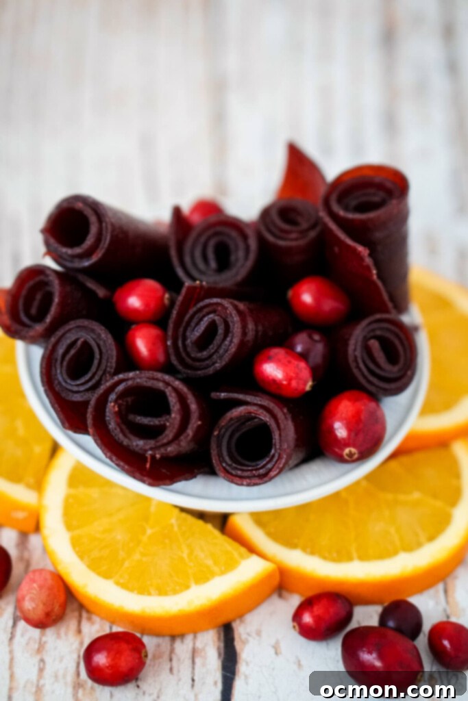 A close up image of the cranberry fruit leather rolls in a white bowl. 