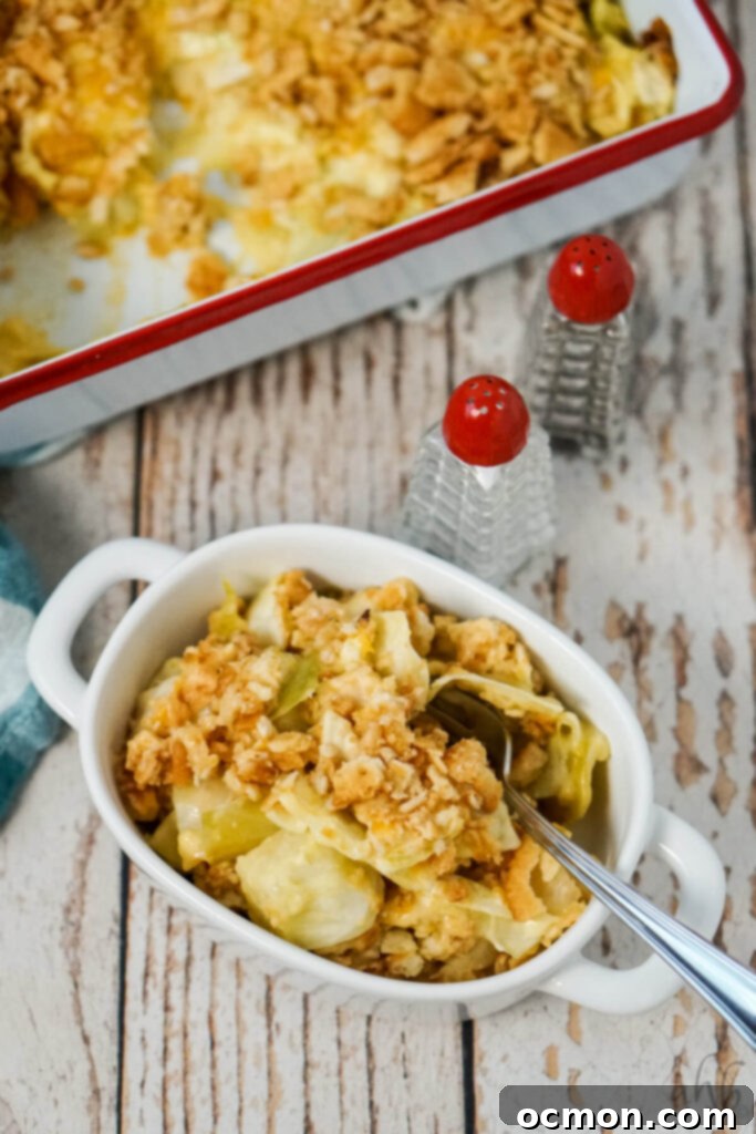 Effortless Creamy Cabbage Bake 3 A generous serving of Scalloped Cabbage Casserole presented in a white bowl, alongside salt and pepper shakers, ready to be enjoyed.