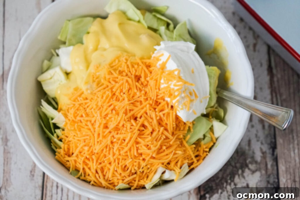 Effortless Creamy Cabbage Bake 5 In a large mixing bowl, chopped cabbage, shredded cheese, a can of cream of chicken soup, and sour cream are combined and stirred thoroughly.