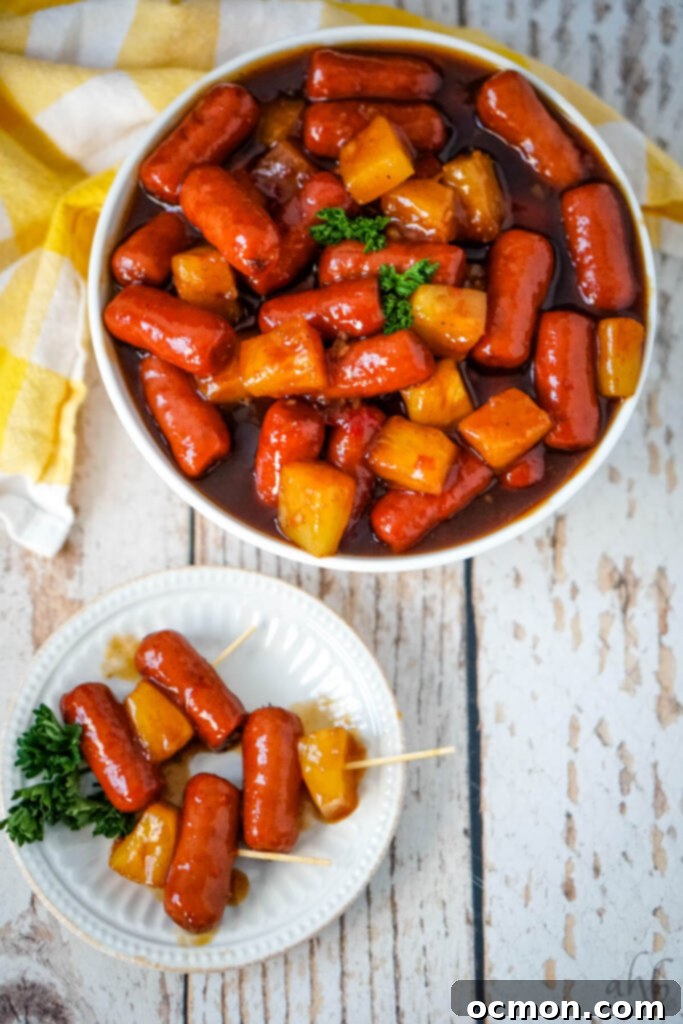 Aloha Smokies 9 A beautiful presentation of Hawaiian Lit'l Smokies: a white bowl overflowing with the savory bites next to a white plate featuring three artfully arranged skewers, perfect for serving.