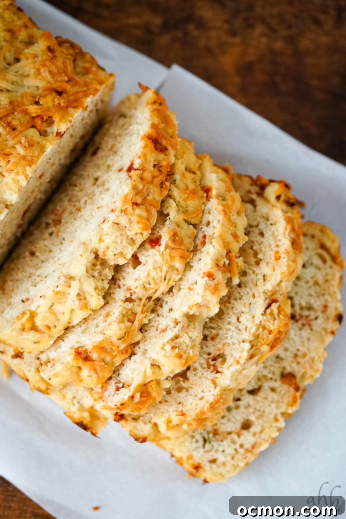 Five thick slices of Sun Dried Tomato and Parmesan Beer Bread, stacked artfully, showcasing their tender crumb and flavorful additions.