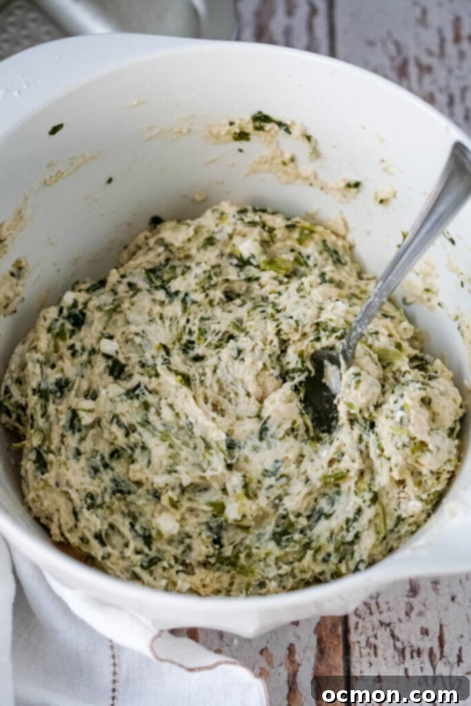 The bread ingredients being mixed together with a fork until a cohesive dough-like consistency is achieved.