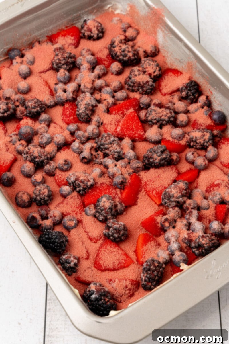 The berries are evenly distributed in the bottom of the pan and covered with sugar and gelatin.