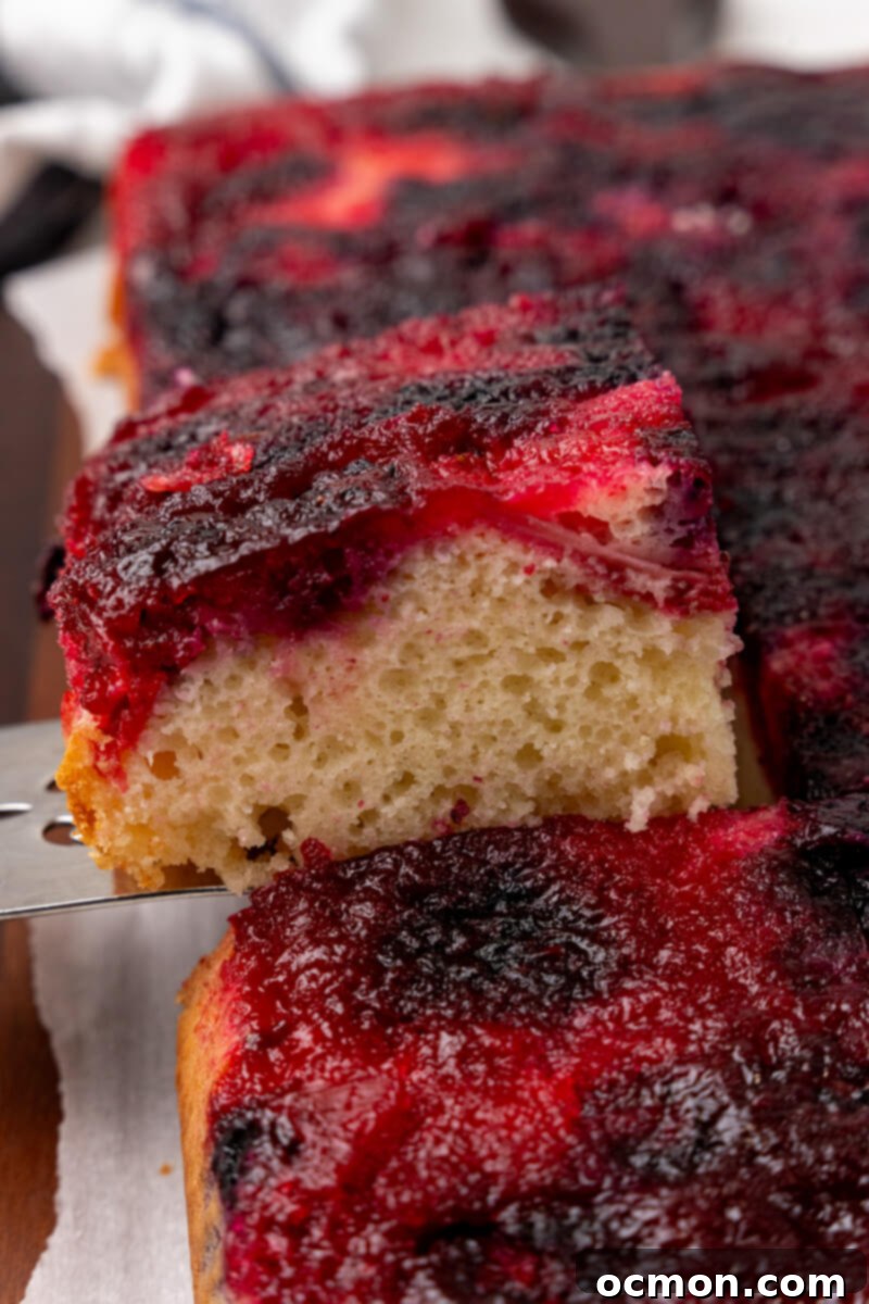 A slice of the Berry Upside Down Cake is taken out of the cake and served.