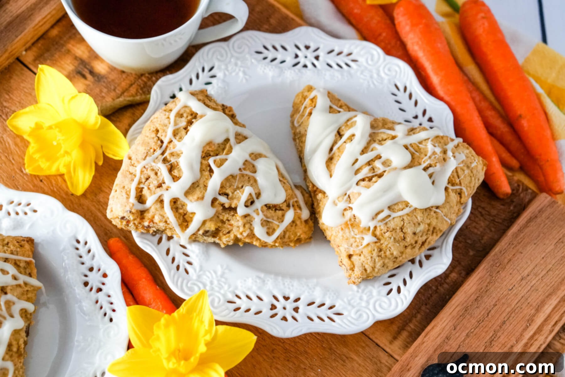 Carrot Cake Mix Scones, a tender breakfast treat with cream cheese glaze, served on a white plate with yellow flowers.