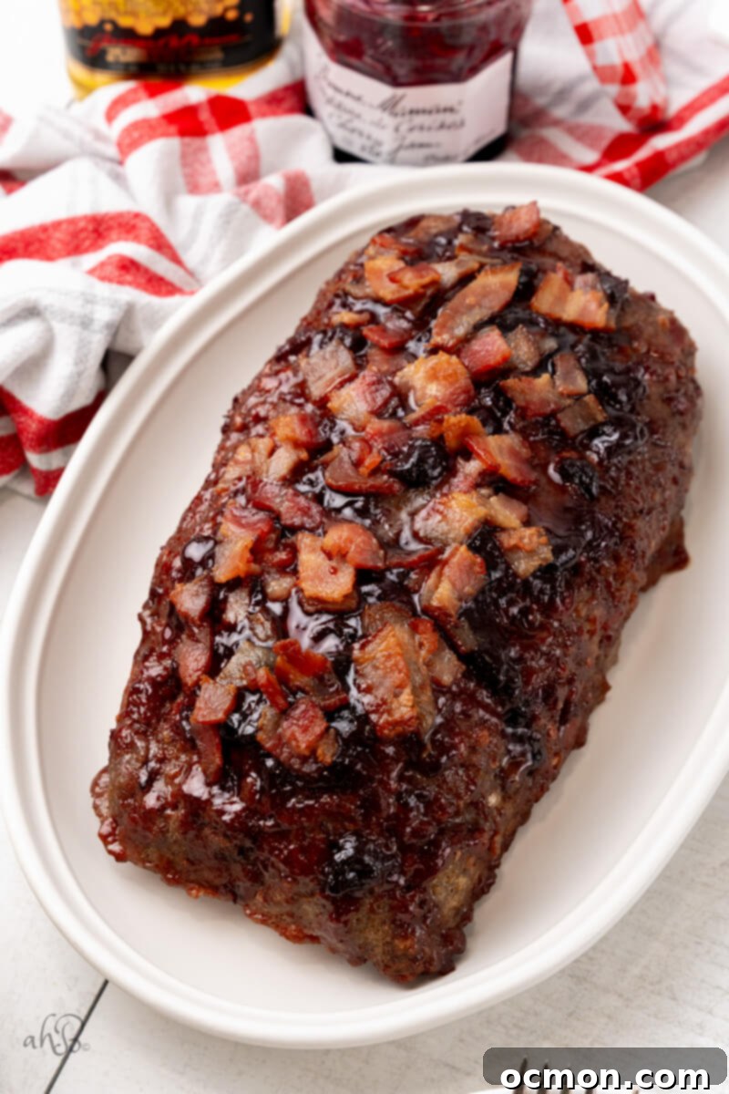 A stunning shot of the Bourbon Bacon Meatloaf on a white platter, ready to be served.