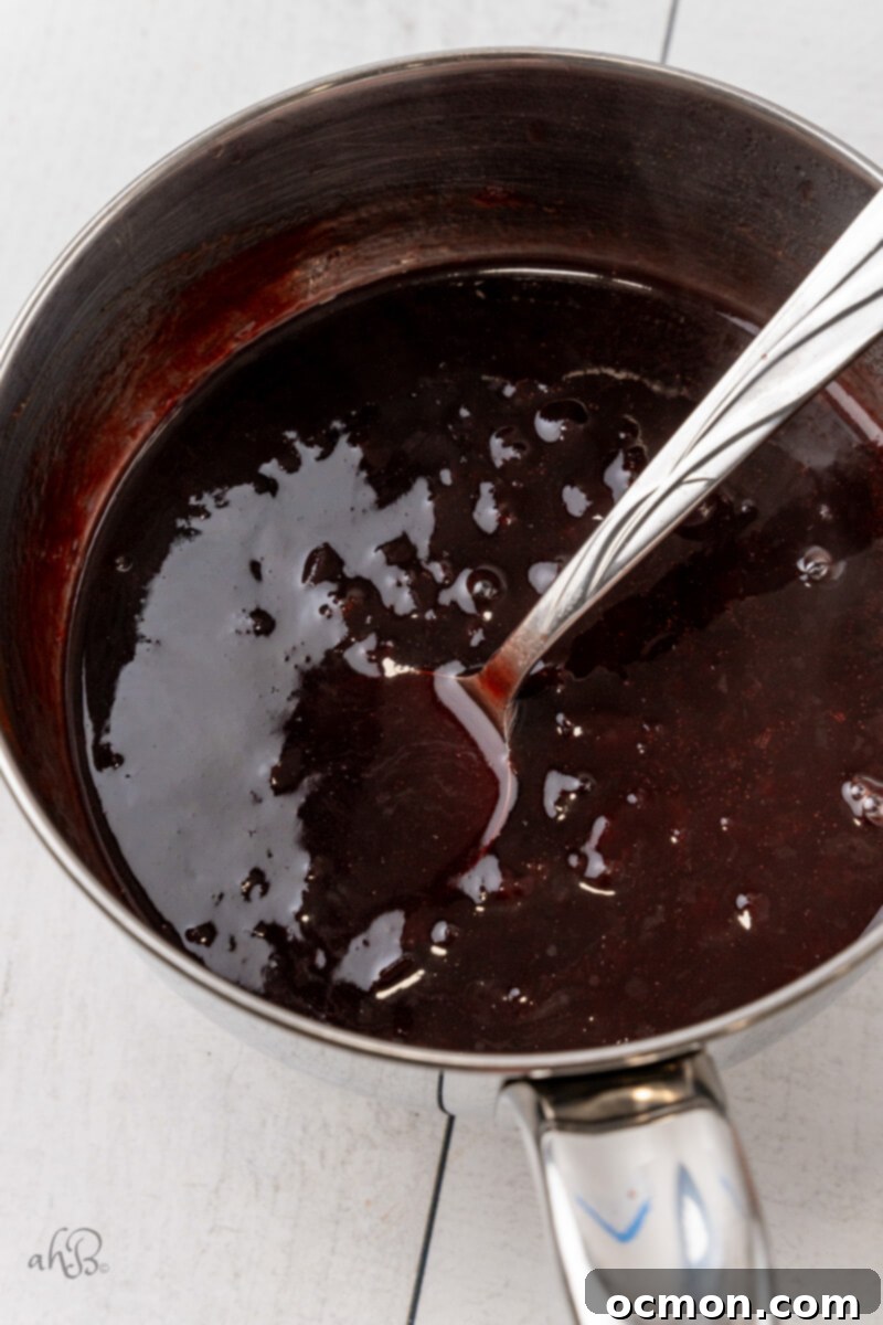 The luscious bourbon glaze is being stirred in a saucepan on the stove, gleaming under the light.