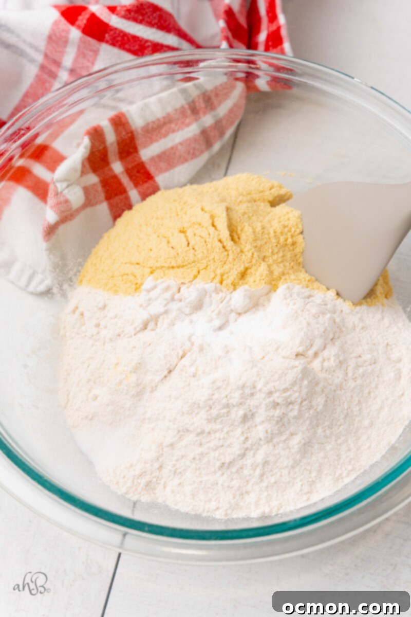 The dry ingredients – flour, baking soda, salt, and malted milk powder – are perfectly mixed in a clear glass bowl.
