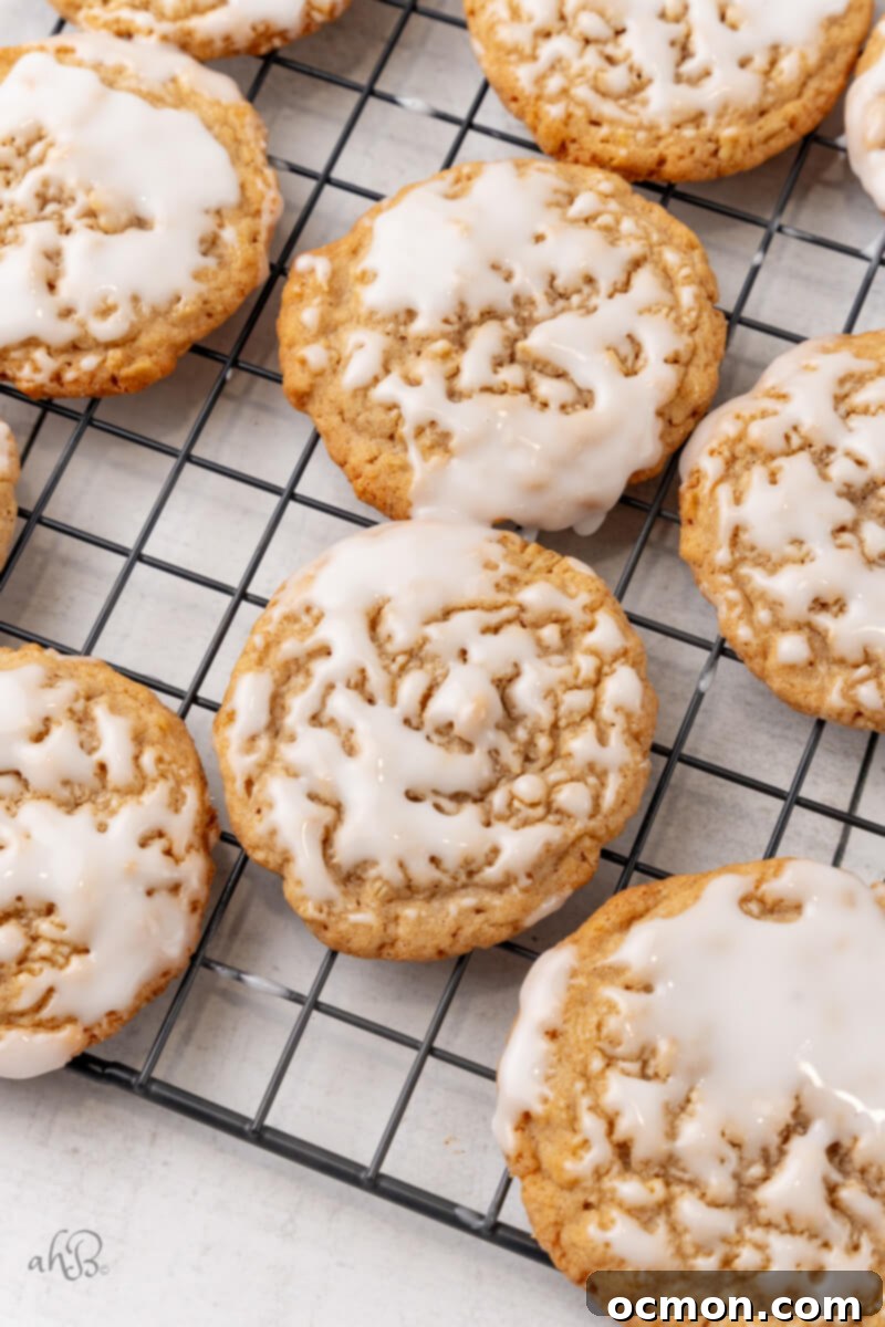 Iced Oatmeal Cookies-10 More perfectly iced oatmeal cookies are cooling on a wire rack, the icing glistening and set, promising a delicious treat.