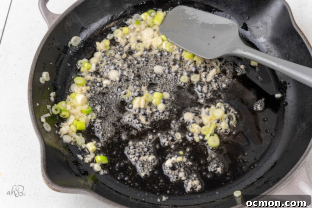 The green onions are cooked in the bacon grease in the same skillet.