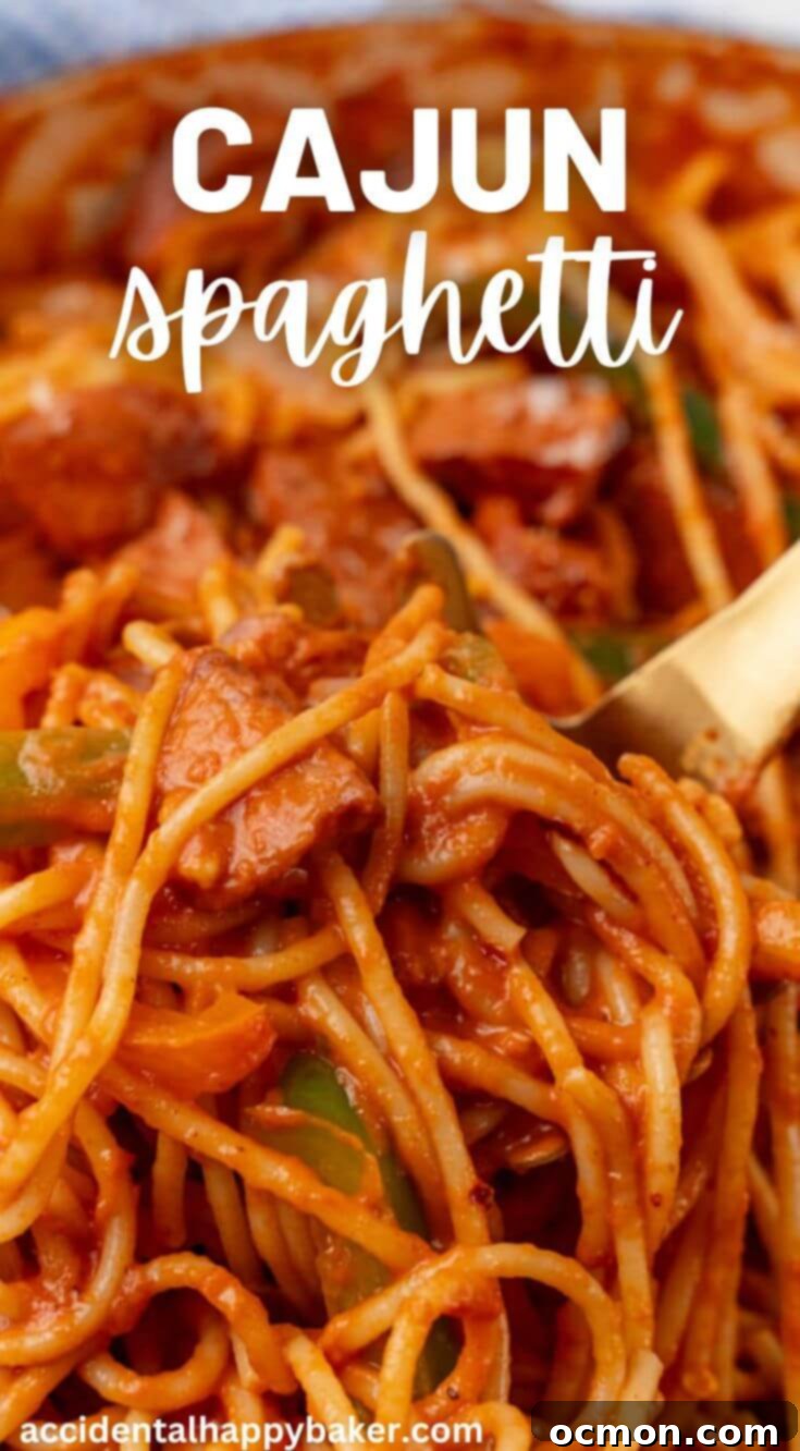 A close up of Cajun Spaghetti in a bowl, topped with cheese and red pepper flakes.