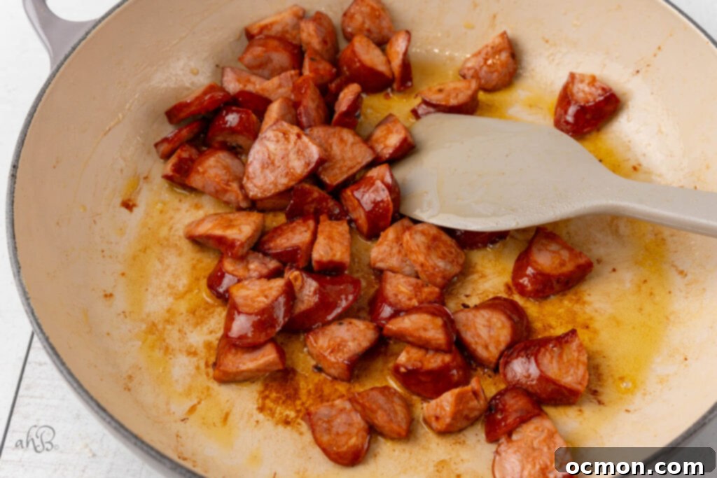 The sausage is heated in the pot and stirred with a spatula.
