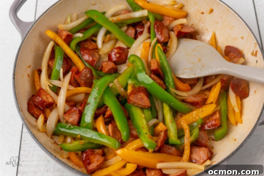 The onions and peppers are added to the pot and stirred.