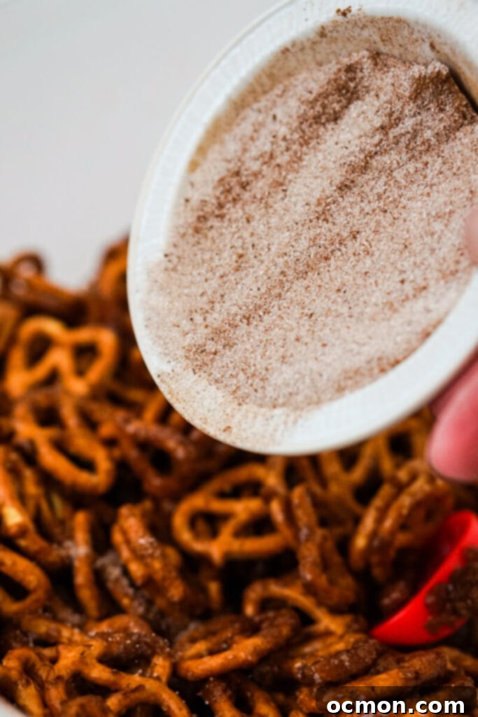 Spiced Apple Cider Pretzels 8 The golden-brown sugar-spice mixture is generously poured over the mini pretzels, ready for mixing and microwaving.