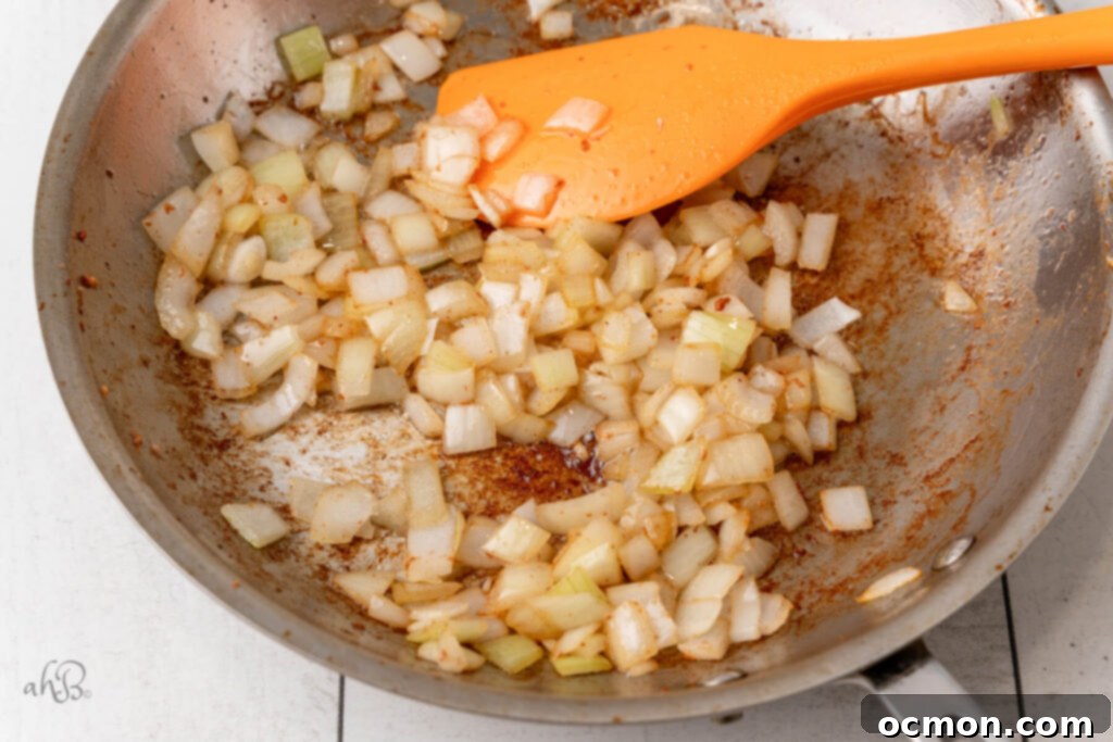 Diced onion is sauteed in the skillet with bacon drippings, becoming translucent.