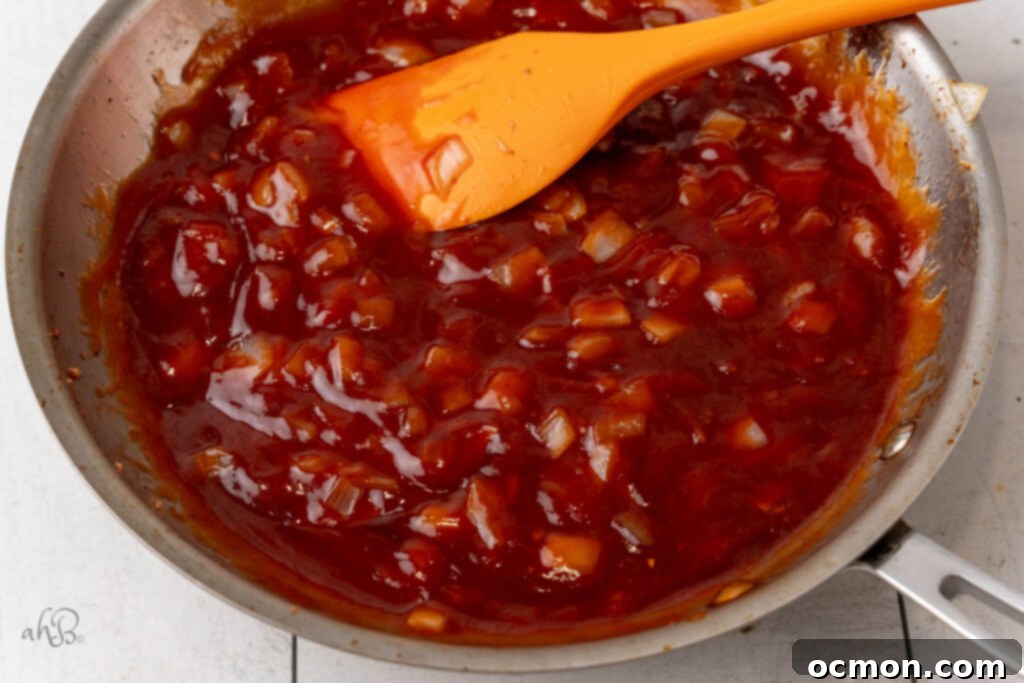 The BBQ mixture, including ketchup, brown sugar, and Worcestershire sauce, is simmered in the skillet.