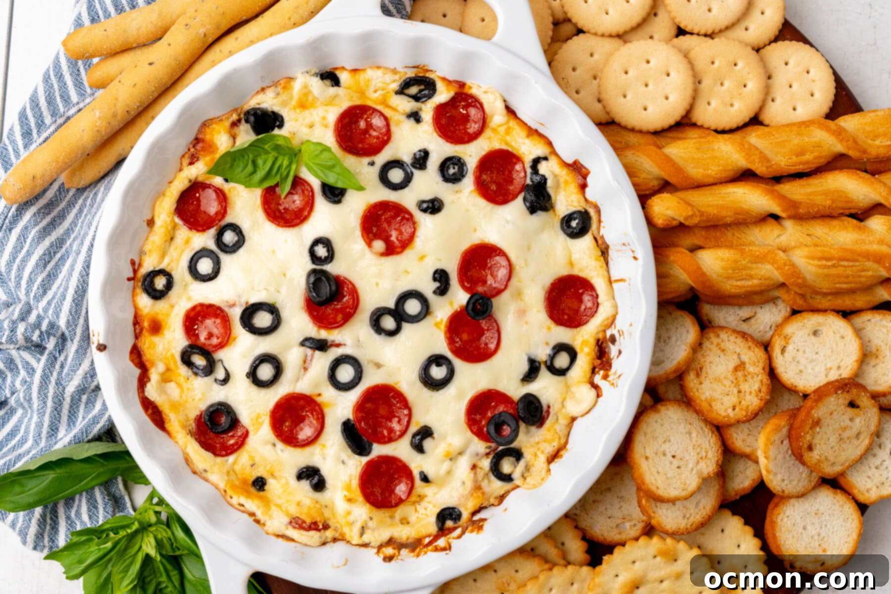 A delicious Cheesy Pepperoni Pizza Dip served with an assortment of crackers and breadsticks.