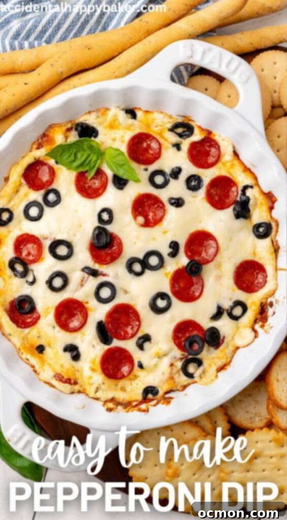 Hot and gooey Pepperoni Dip in a pie plate, garnished with more pepperoni, served alongside a variety of crackers and breadsticks.