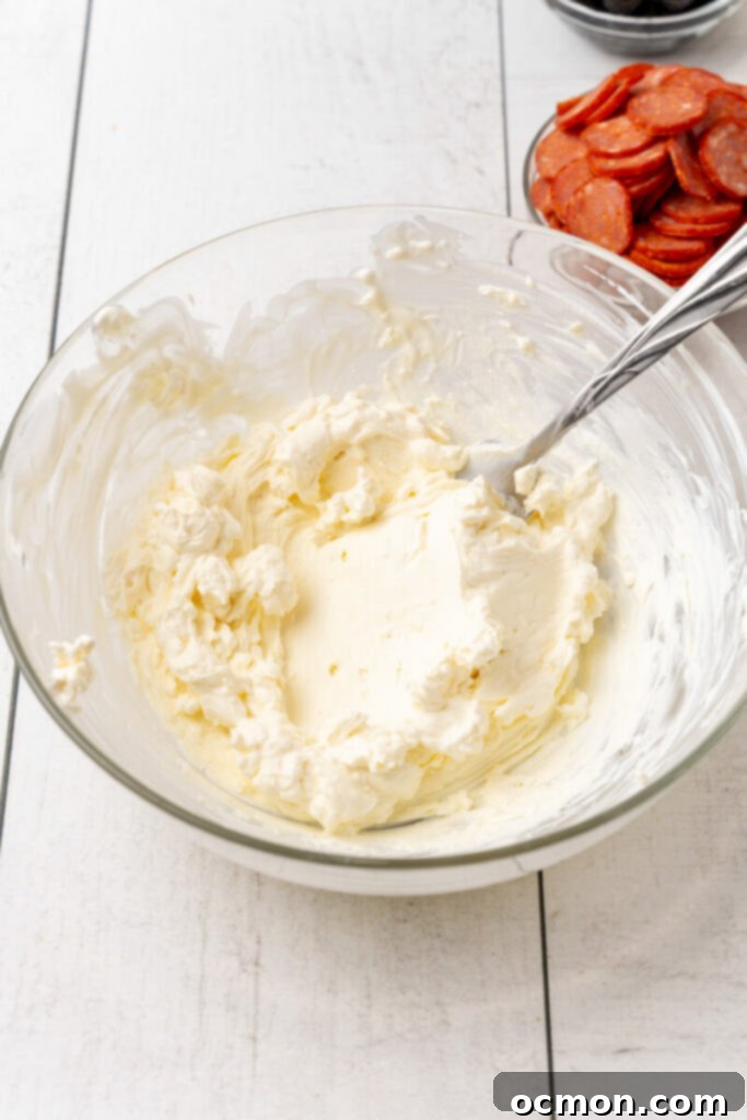 Add the softened cream cheese to a medium sized bowl along with the sour cream. Beat the cheese and sour cream together until smooth.