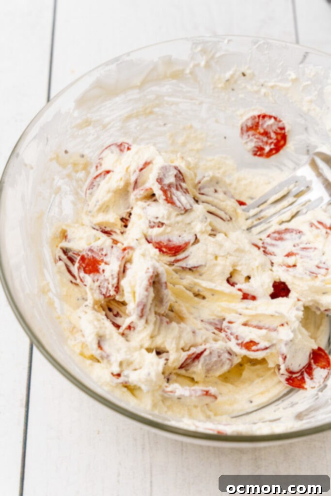 Add the parmesan cheese, basil, garlic salt, crushed red pepper and mix well. Set aside a small amount of pepperoni to use as the garnish for dip and and the rest of the pepperoni to the bowl, mixing well.