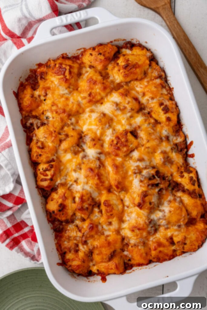 The golden brown, freshly baked Sloppy Joe Biscuit Casserole sitting on a cooling rack, with bubbly melted cheese and perfectly cooked biscuits.