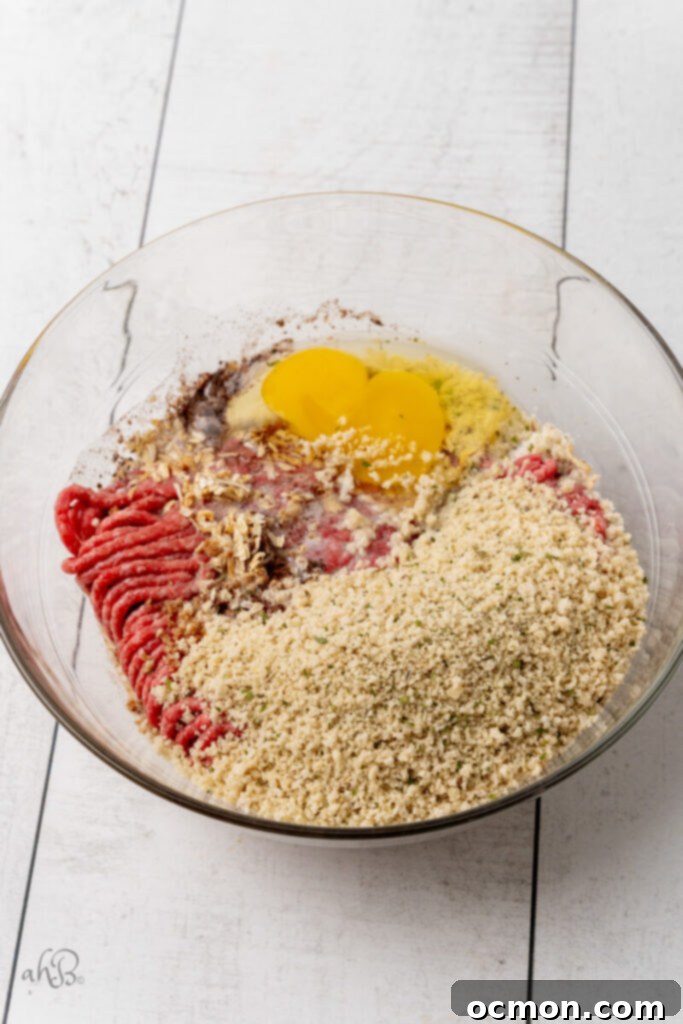 A clear glass bowl full of the mixed ingredients for the Swedish meatballs, ready for shaping.
