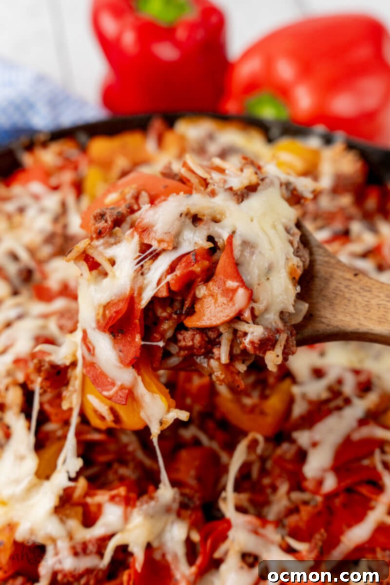 Skillet Pizza Peppers 2 A wooden spoon scoops the Pizza Unstuffed Peppers Skillet.