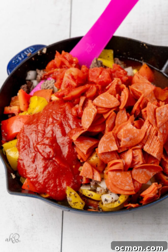 Skillet Pizza Peppers 5 The pepperoni and tomato sauce are added to the skillet.