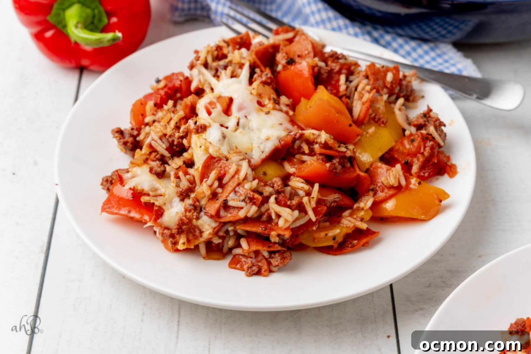 Skillet Pizza Peppers 7 A top-down view of the One-Pan Pizza Unstuffed Peppers Skillet with melted cheese and a spoon inside.