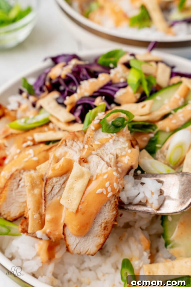 A piece of chicken is taken from the bowl with a fork.