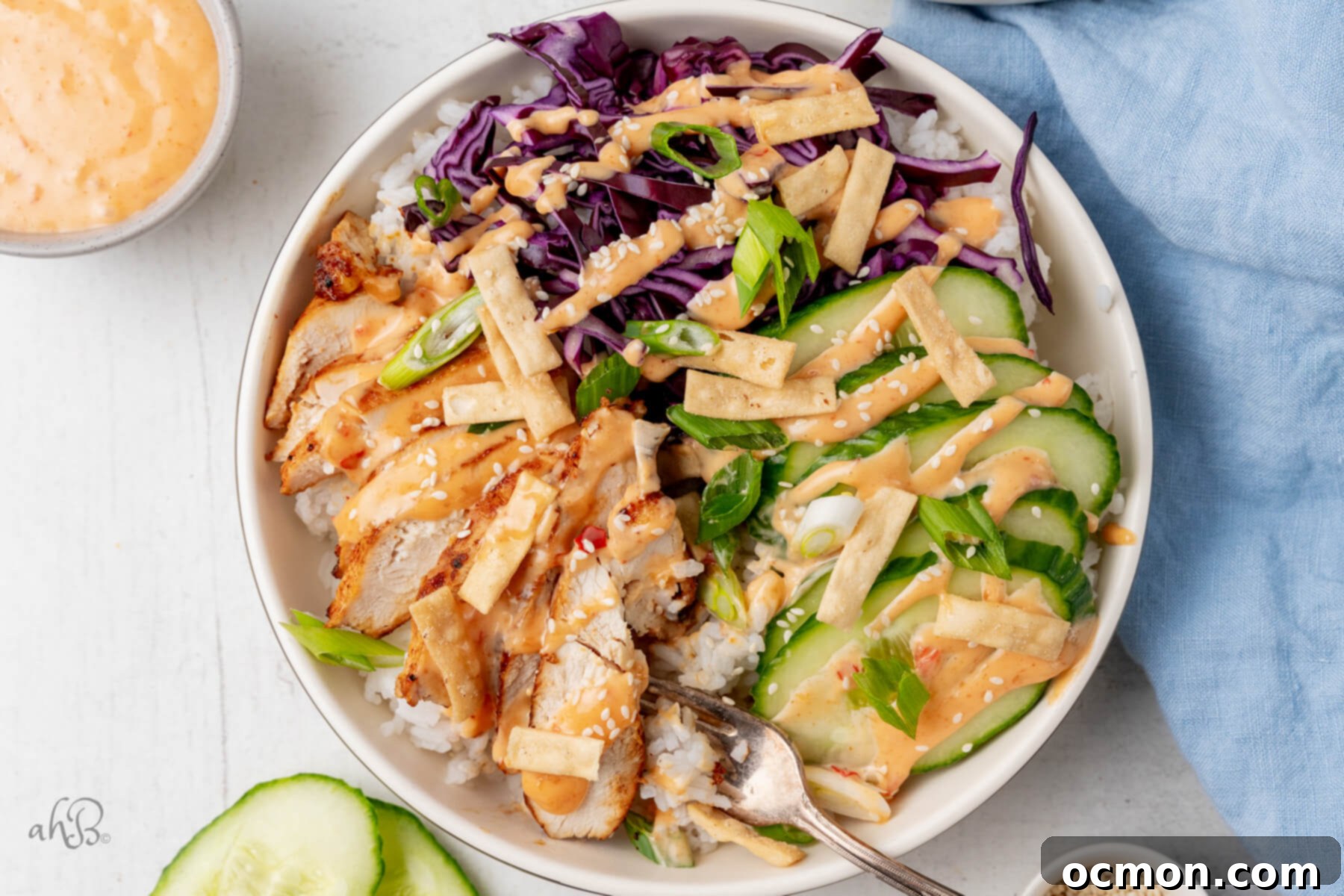 Bang Bang Chicken Bowls with a side of sauce and fresh ingredients.