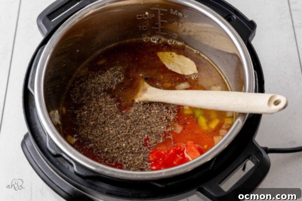 Basil, thyme, marinara sauce, tomatoes, bay leaf, vegetable broth, and ditalini pasta are added to the Instant Pot.