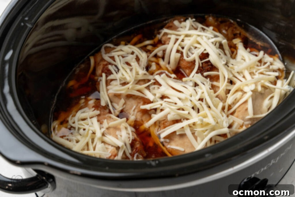 Easy Slow Cooker French Onion Chicken 8 Shredded cheese is added to the crockpot.