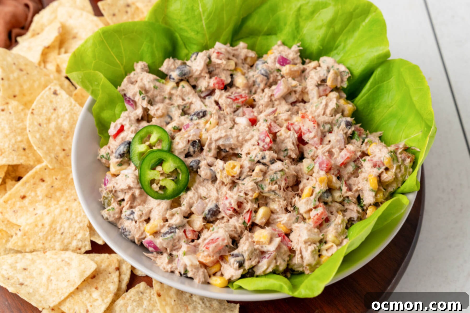Mexican Tuna Salad in a bowl lined with lettuce and two slices of jalapeños.
