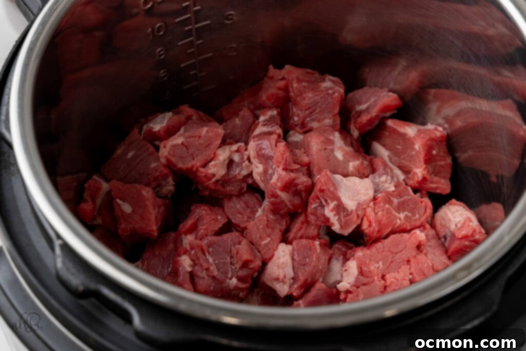 The cubed beef is added to the instant pot.