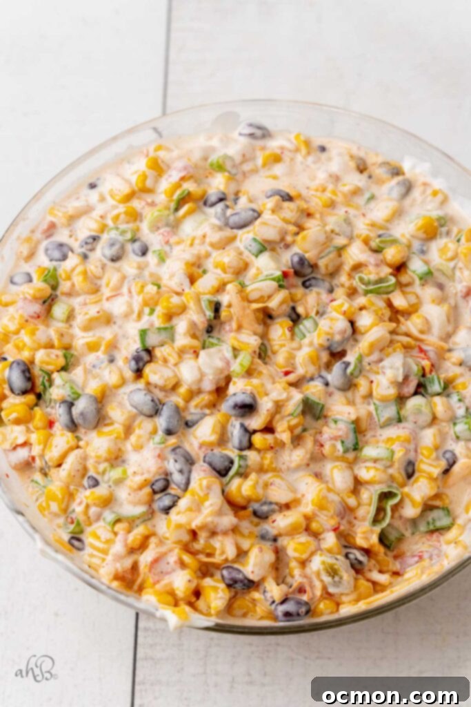 Step 2: The ingredients in the large bowl are being thoroughly mixed with a spoon until everything is uniformly combined and creamy. 