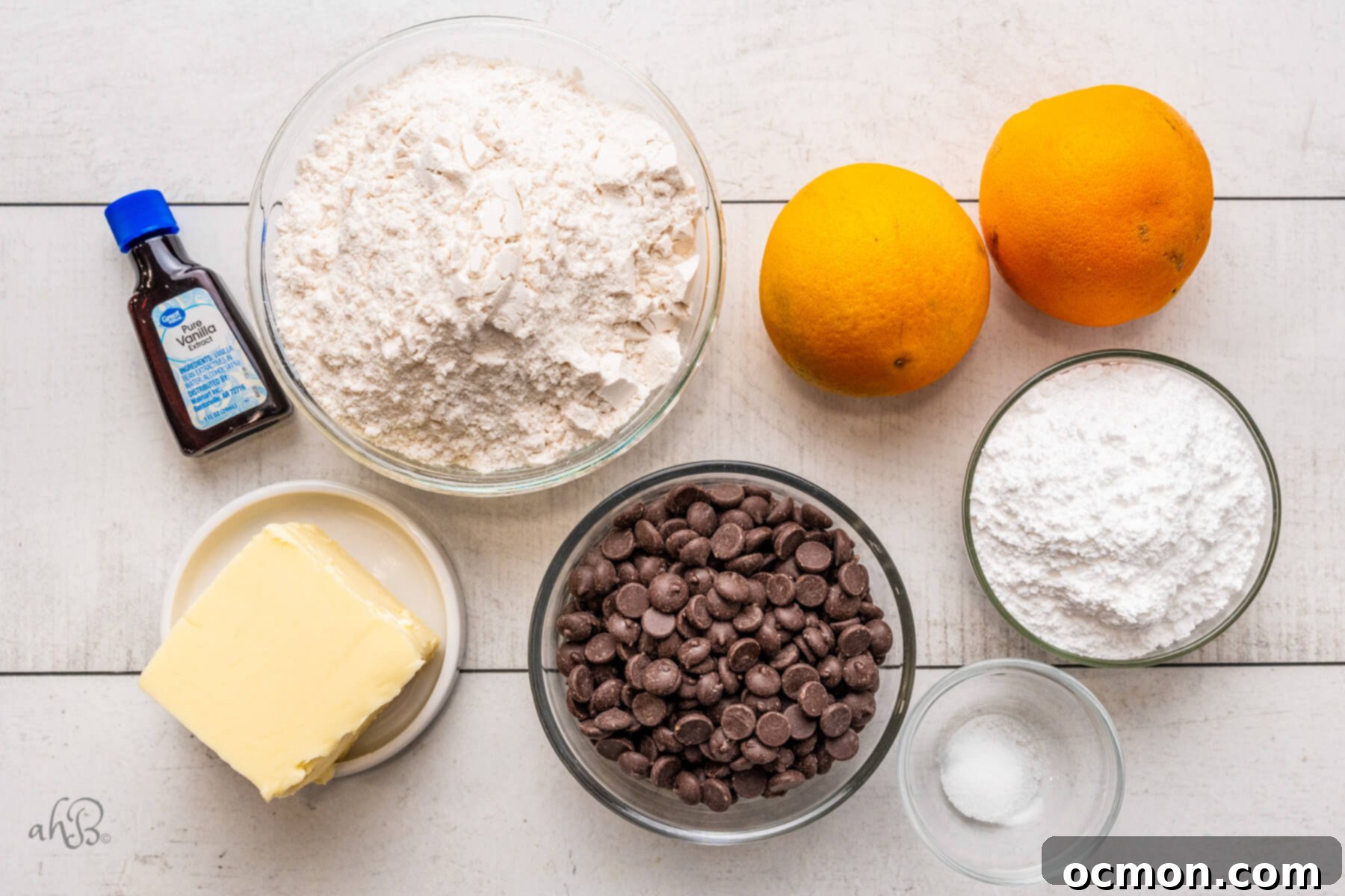Orange Zest Chocolate Shortbread 5 Arrangement of ingredients for Chocolate Orange Shortbread Cookies: vanilla extract, all-purpose flour, softened butter, dark chocolate chips, confectioners sugar, a pinch of salt, and two fresh oranges, emphasizing fresh ingredients.
