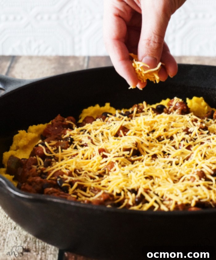 Chili Cheese Polenta; Crispy-edged, creamy-centered polenta topped with chili, cheese, and crunchy crushed nacho chips. No one will ever guess that this chili cheese polenta is a frugal leftover makeover, unless you tell them that is!
