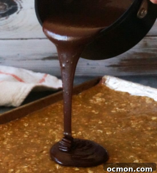 Decadent Chocolate Revelry Bars 4 Pouring the luscious chocolate fudge topping over the buttery oatmeal crust in a baking pan, creating a perfect layer for homemade revel bars.