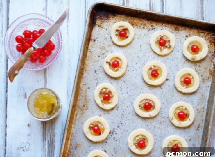 A tray of freshly baked Pineapple Cookies before glazing, showing the golden pastry and pineapple-cherry centers.