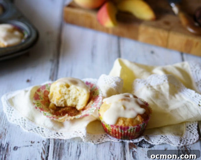 Golden Peach Cloud Muffins 4 Several golden brown Peaches and Cream Muffins arranged in a muffin tin, fresh from the oven, with a delicate vanilla glaze dripping down the sides