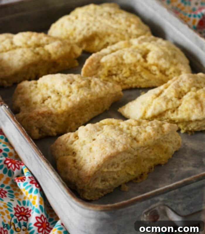 Close-up of a stack of lemon sugar scones, highlighting their light texture and sugary lemon glaze.