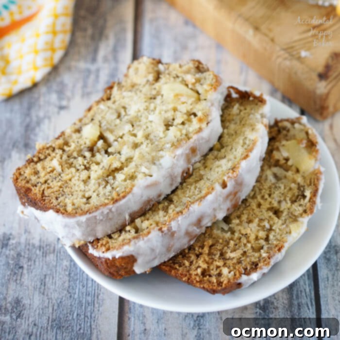 Deliciously moist Pina Colada Banana Bread, sliced and ready to serve with pineapple and coconut garnish