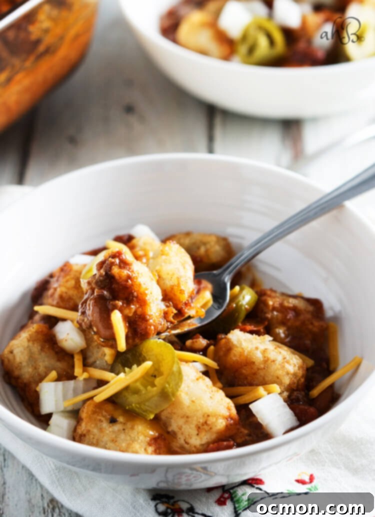 Loaded Chili Cheese Tater Tot Bake 4 A spoonful of tater tots and chili with cheese.
