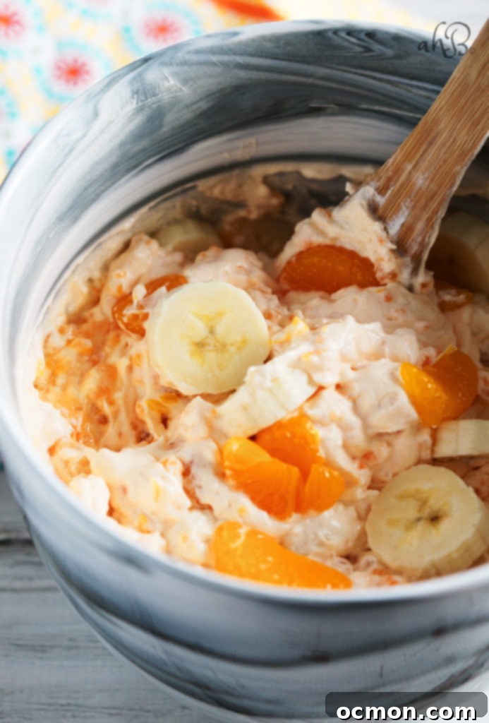 Close-up of Orange Dream Salad, highlighting the fluffy whipped topping and fresh banana slices.